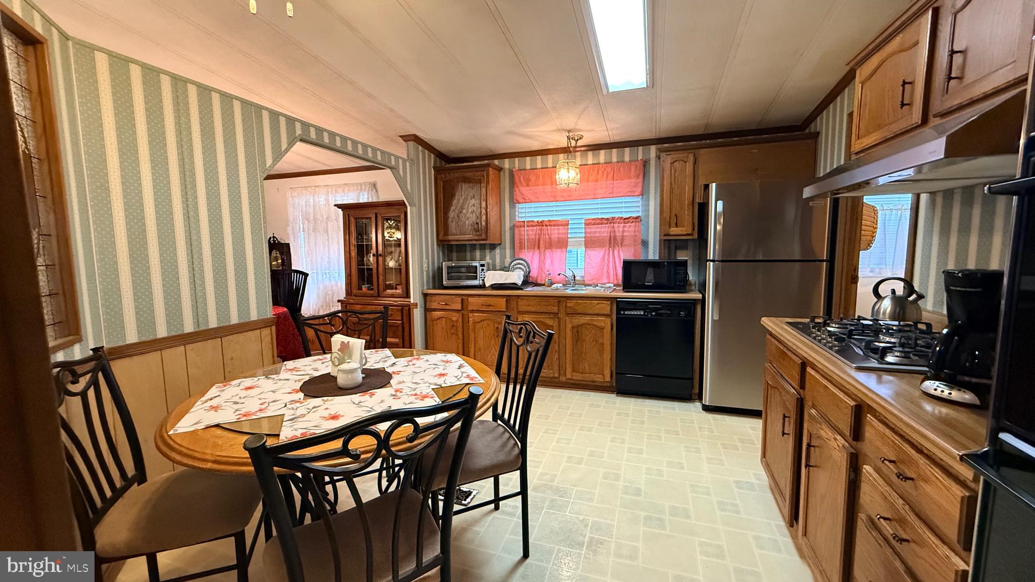 581 Miles Standish Lane Buena, NJ 08310 - Photo 11 of 34 a kitchen with stainless steel appliances a dining table and chairs