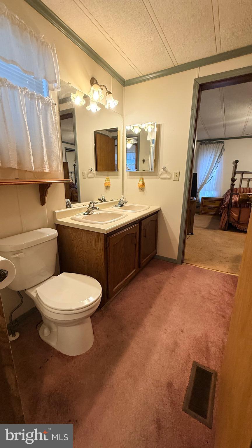 581 Miles Standish Lane Buena, NJ 08310 - Photo 6 of 34 a bathroom with a toilet sink and mirror