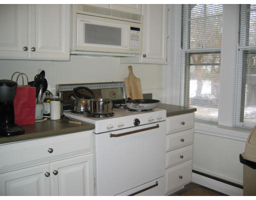 28 Addington Road, Unit 2 Brookline, MA 02445 - Photo 4 of 14 a kitchen with granite countertop white cabinets and white appliances