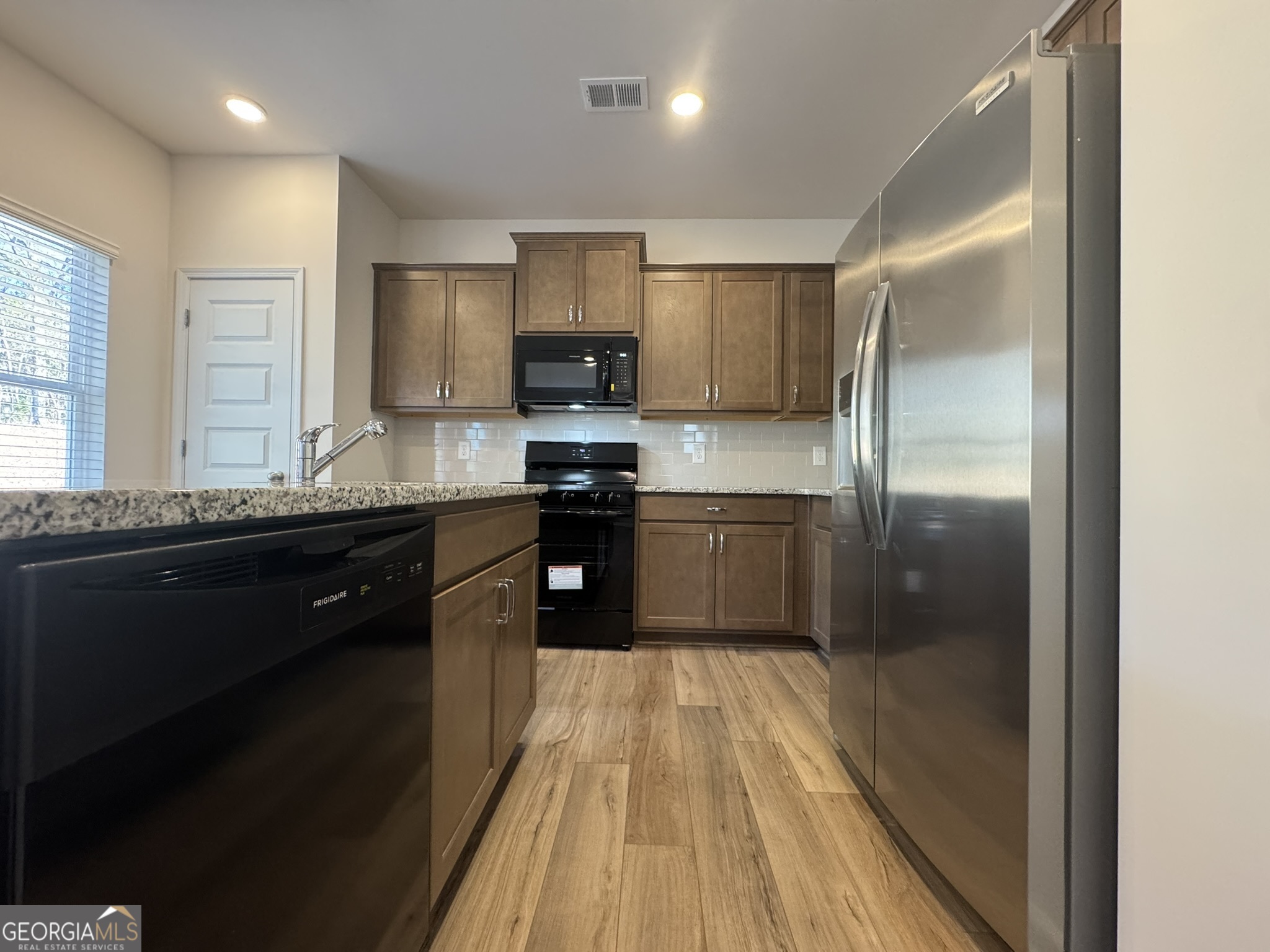 190 Fair Oak Lane Calhoun, GA 30701 - Photo 11 of 30 a kitchen with stainless steel appliances granite countertop a sink a stove a refrigerator and cabinets