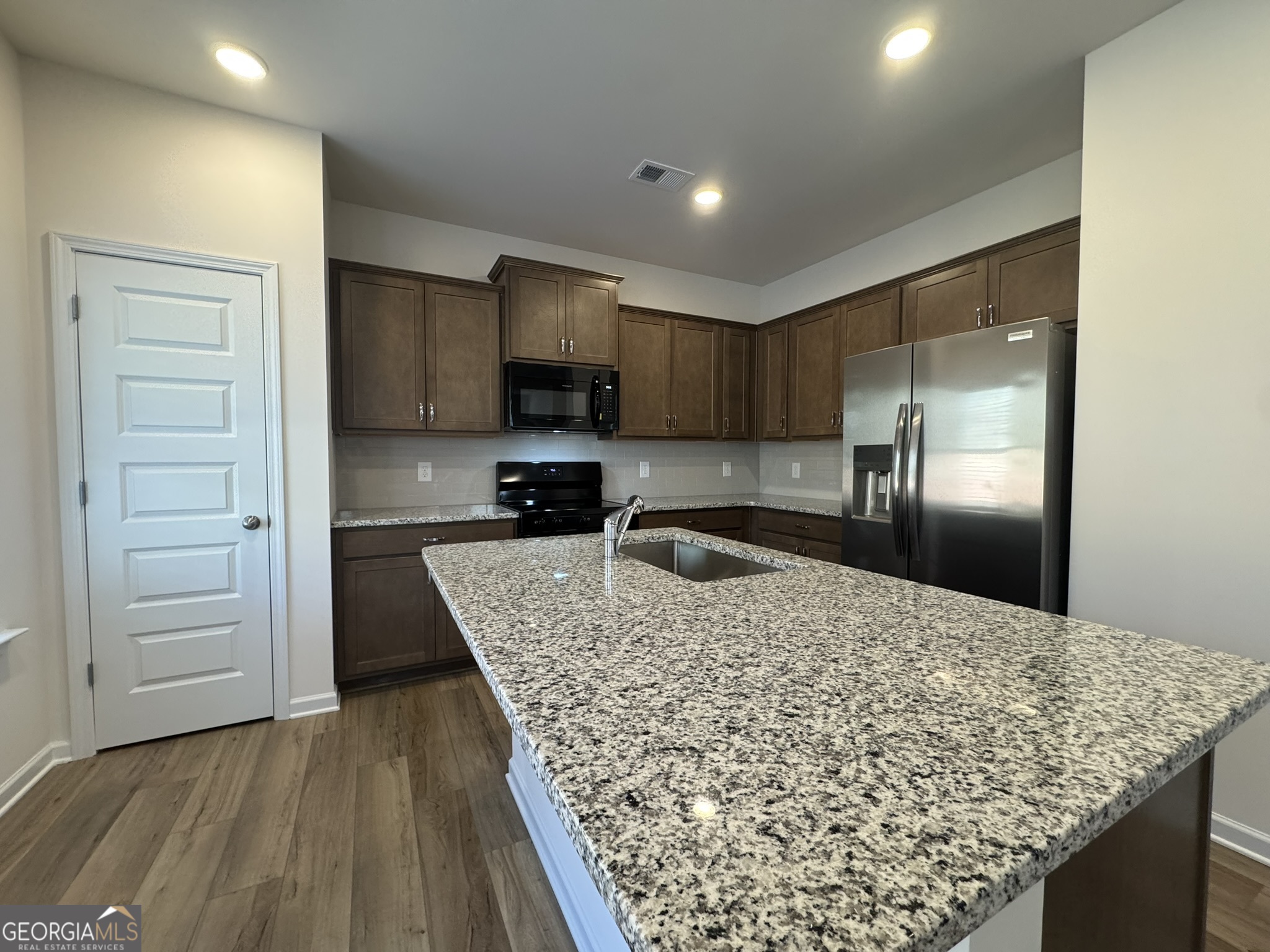 190 Fair Oak Lane Calhoun, GA 30701 - Photo 9 of 30 a kitchen with stainless steel appliances kitchen island granite countertop a refrigerator and a sink