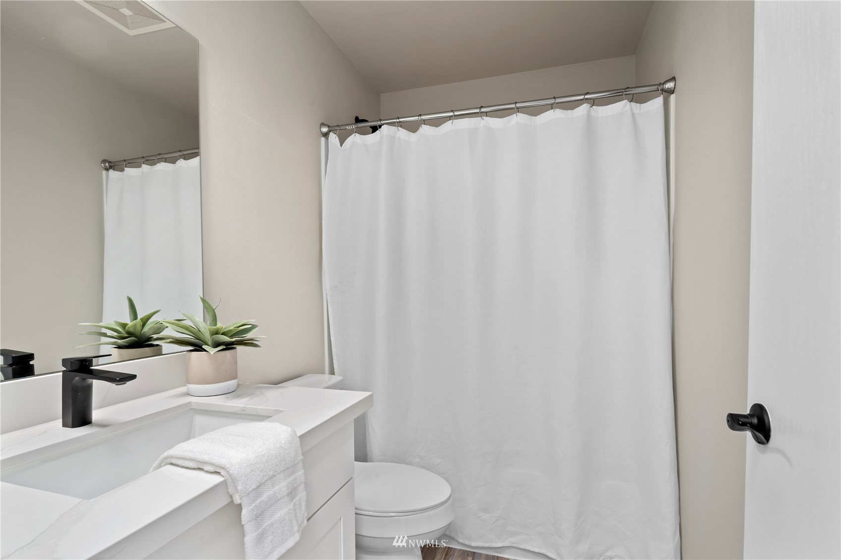 4518 Northeast 7th Place Renton, WA 98059 - Photo 15 of 24 a bathroom with a sink a toilet a window and shower curtain