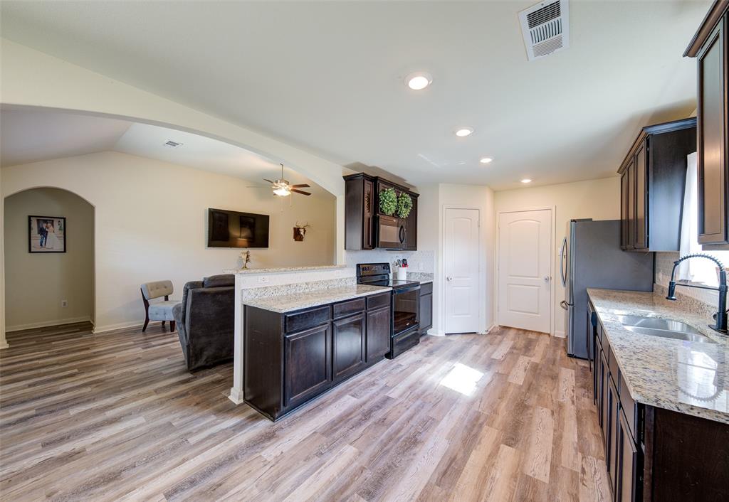 3003 Watercrest Drive Sanger, TX 76266 - Photo 21 of 21 a large kitchen with a center island wooden floor stainless steel appliances and living room view