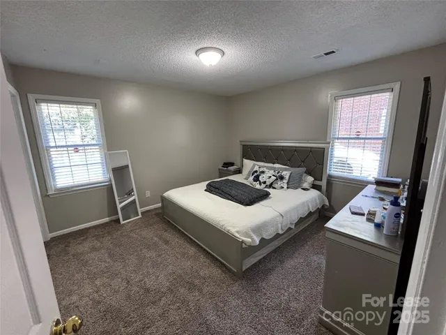 a bedroom with a bed next to a window