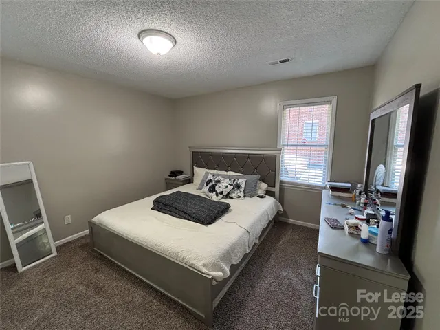 a bedroom with a bed and a flat tv screen on the dresser