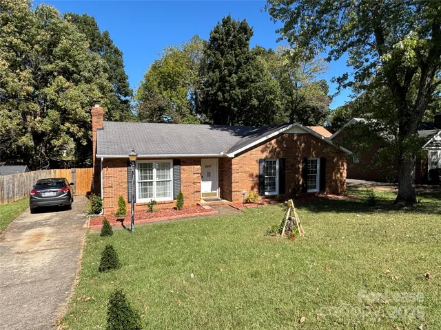 a view of a house with a backyard and a tree