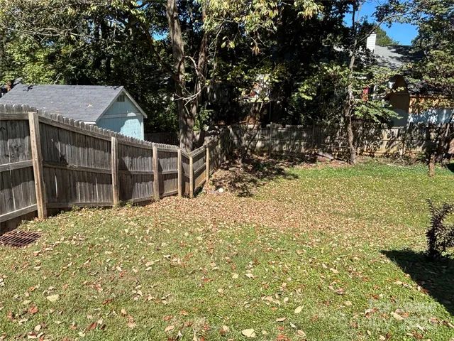 a backyard of a house with a large tree