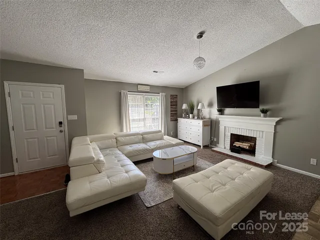 a living room with furniture a fireplace and a flat screen tv