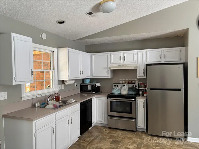 a kitchen with a sink appliances and cabinets