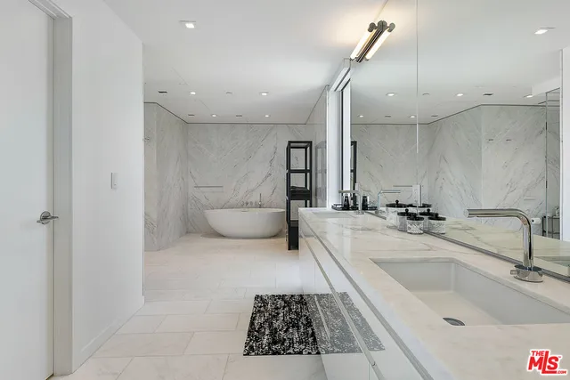 a large white bathroom with a bathtub and a sink