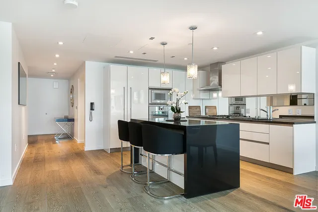 a kitchen with kitchen island granite countertop a sink cabinets and refrigerator