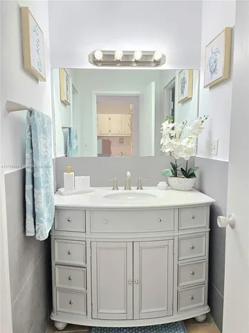 a bathroom with a sink vanity granite and a mirror
