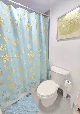 a white toilet sitting next to a shower curtain