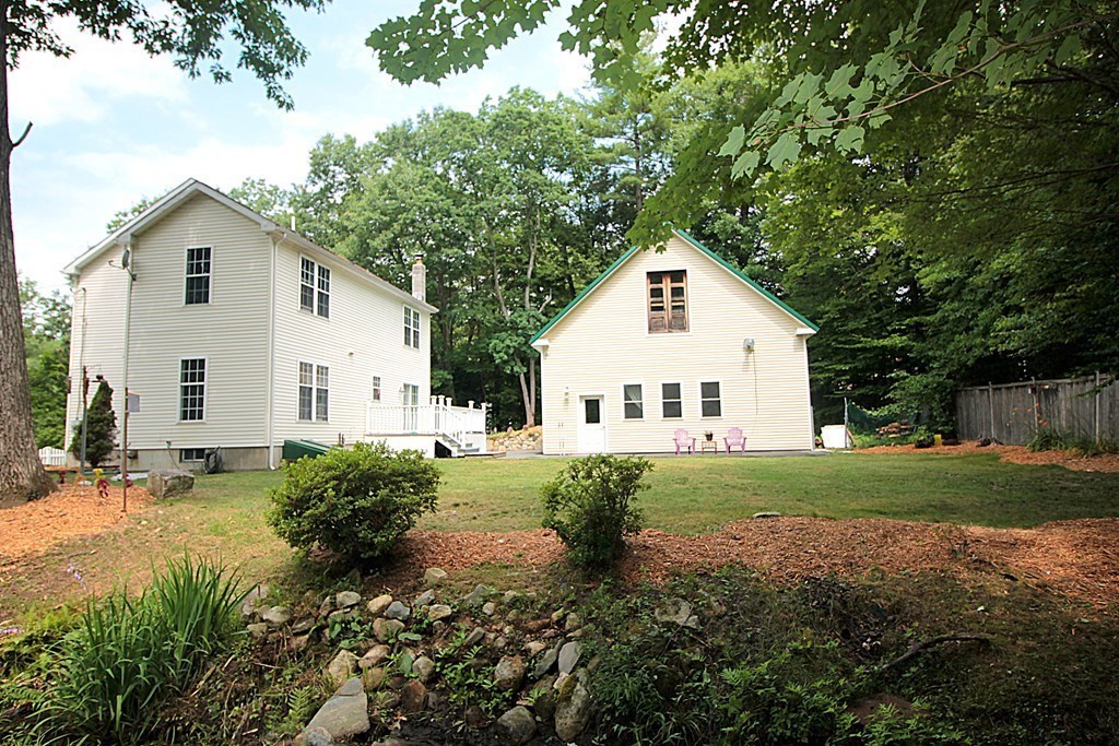 65 High Street Erving, MA 01344 - Photo 28 of 39 a view of a white house with a yard and table and chairs under an umbrella