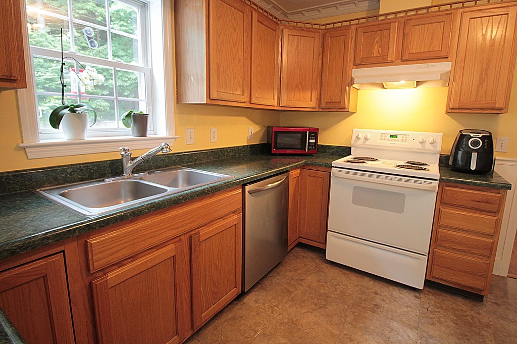 65 High Street Erving, MA 01344 - Photo 5 of 39 a kitchen with granite countertop white cabinets and white appliances
