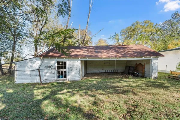 a view of a house with a yard and a tree