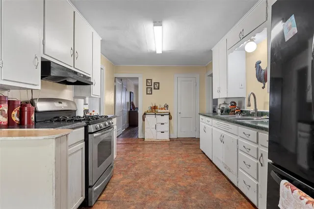 a kitchen with stainless steel appliances granite countertop a stove a sink and a refrigerator
