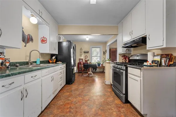 a kitchen with sink stove and refrigerator