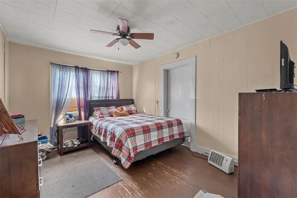 a bedroom with a bed a chandelier and dresser