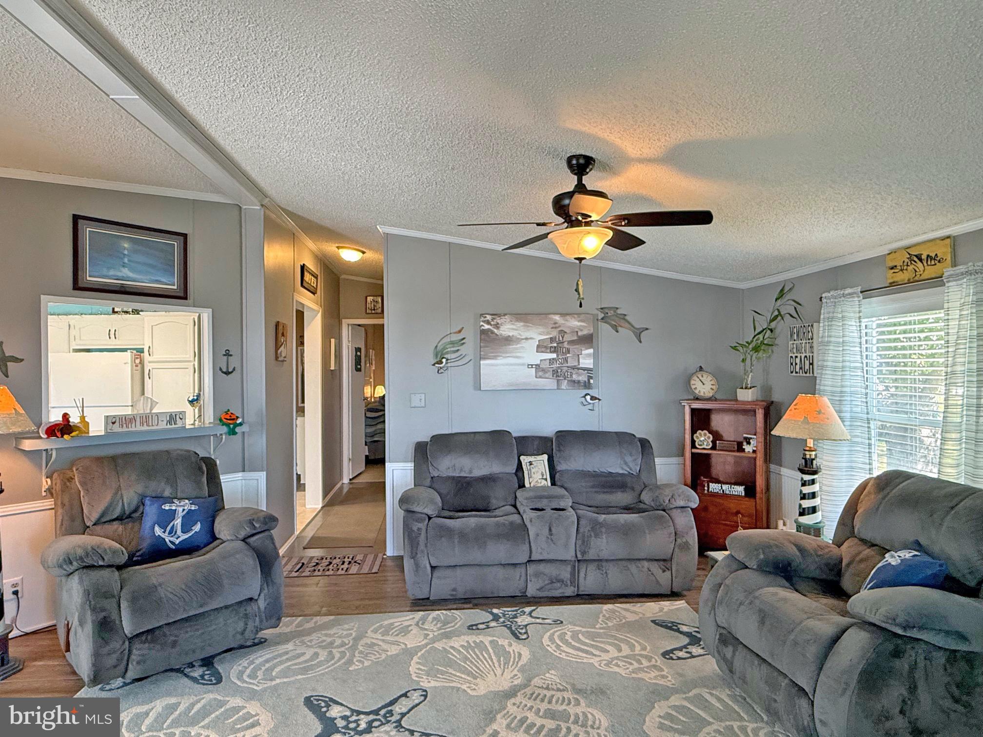 27137 Clipper Road, Unit M55 Millsboro, DE 19966 - Photo 17 of 48 a living room with furniture a chandelier and a window