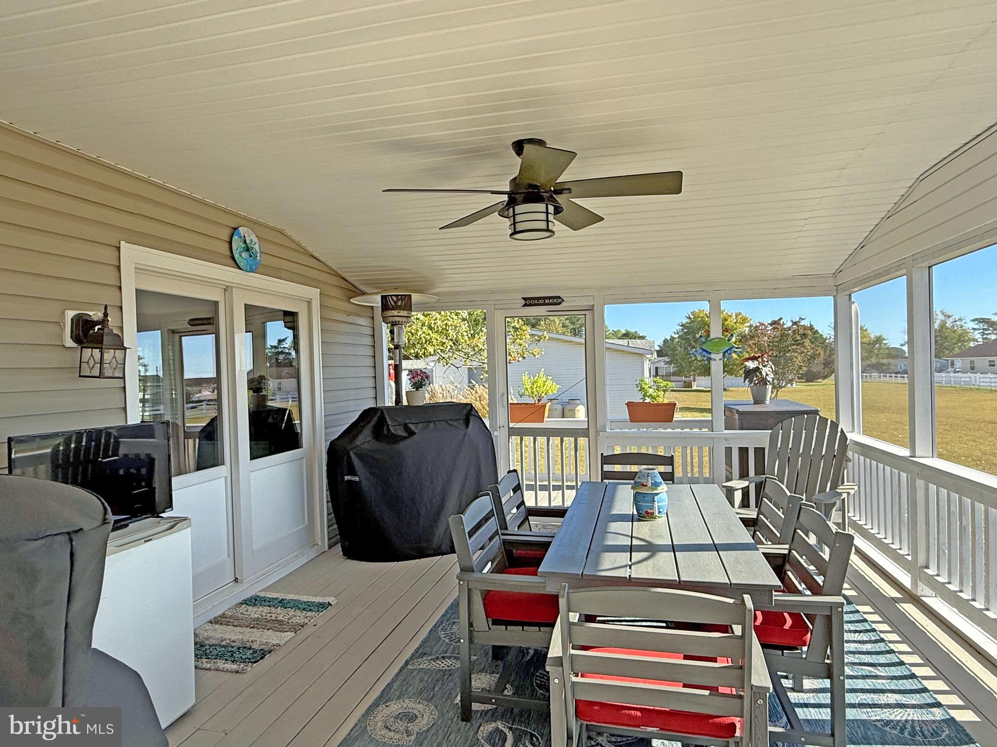 27137 Clipper Road, Unit M55 Millsboro, DE 19966 - Photo 20 of 48 a living room with furniture and a floor to ceiling window