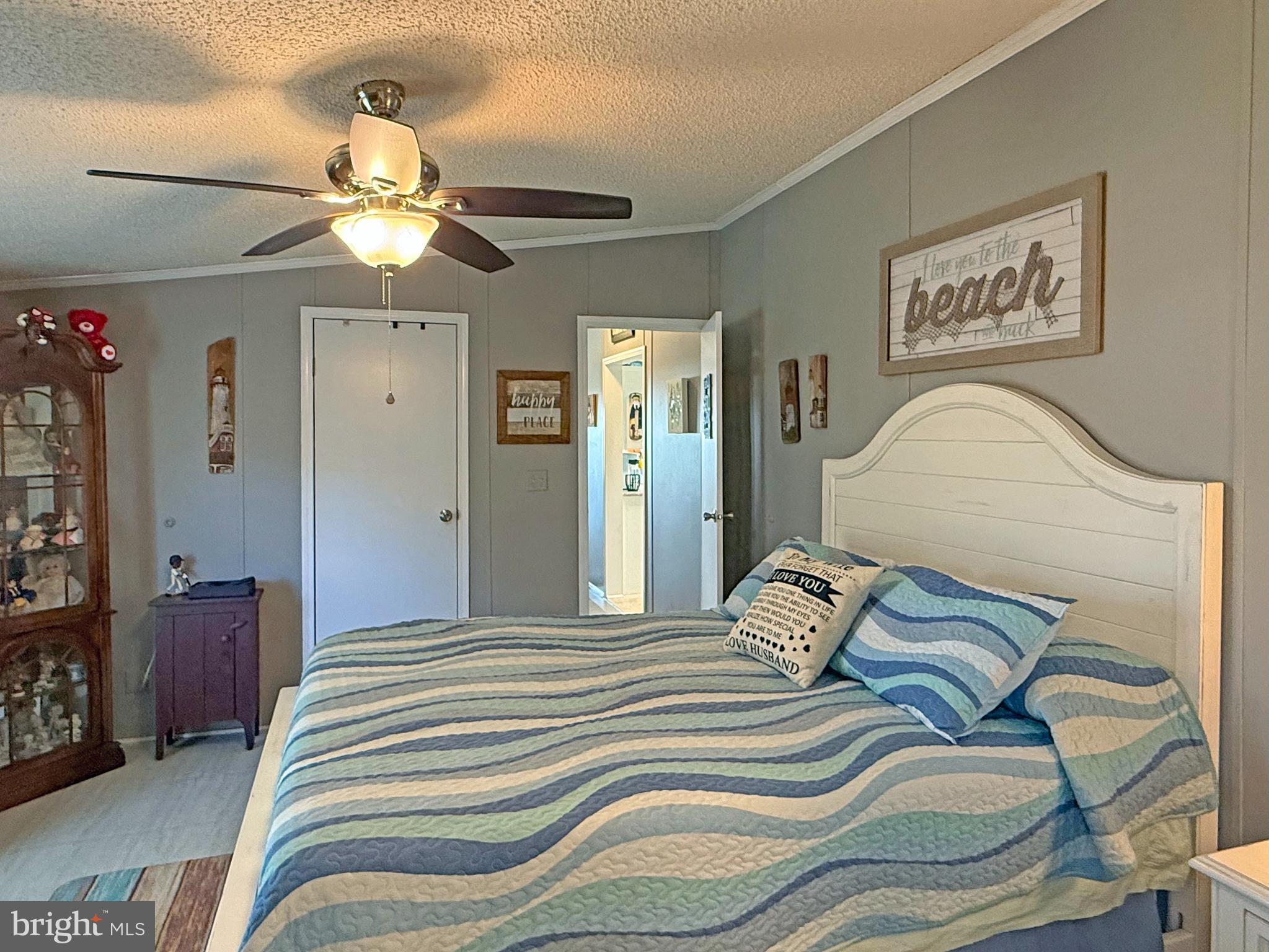 27137 Clipper Road, Unit M55 Millsboro, DE 19966 - Photo 30 of 48 a bedroom with a bed and a chandelier