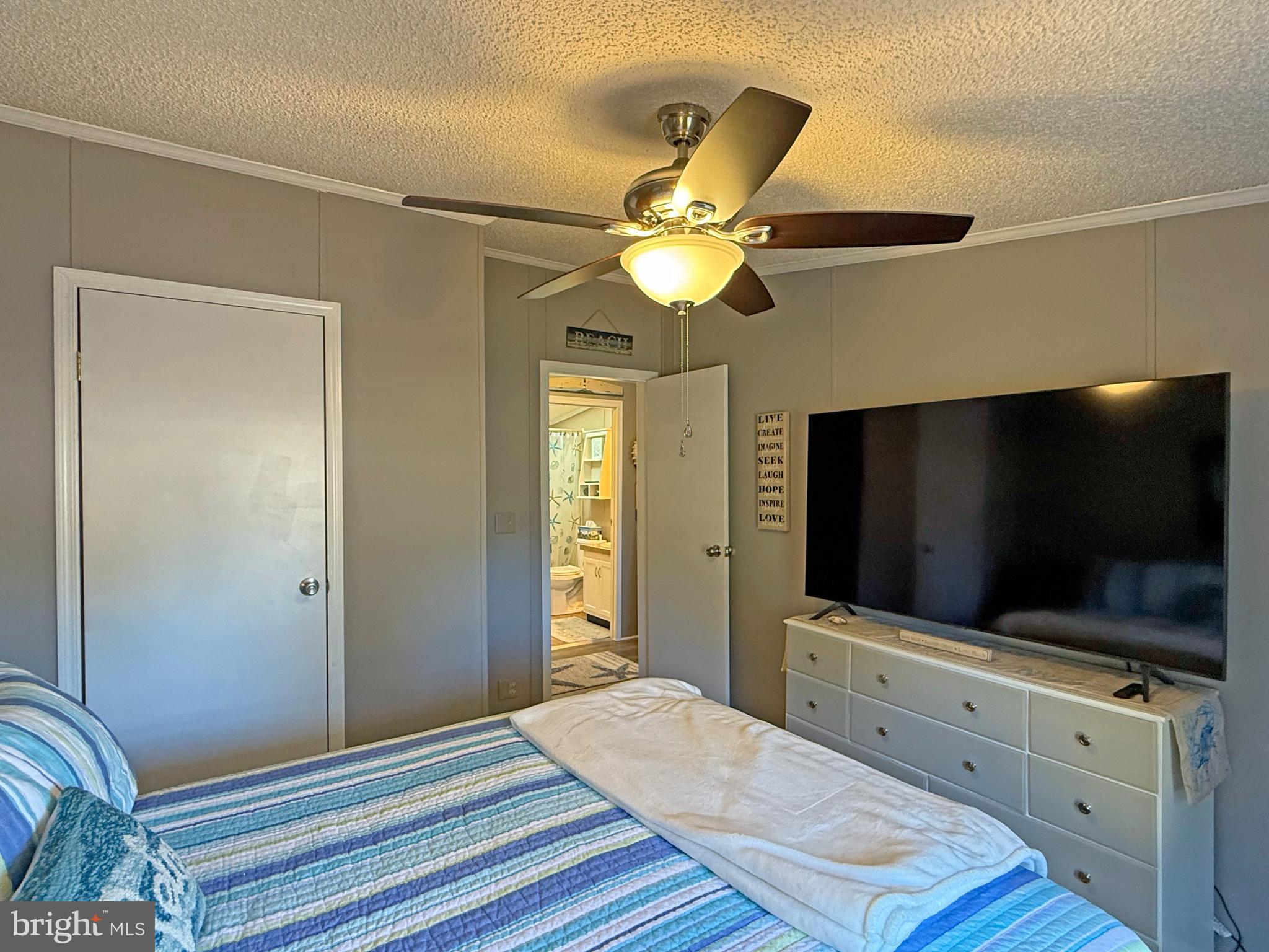 27137 Clipper Road, Unit M55 Millsboro, DE 19966 - Photo 32 of 48 a bedroom with a bed and a flat screen tv