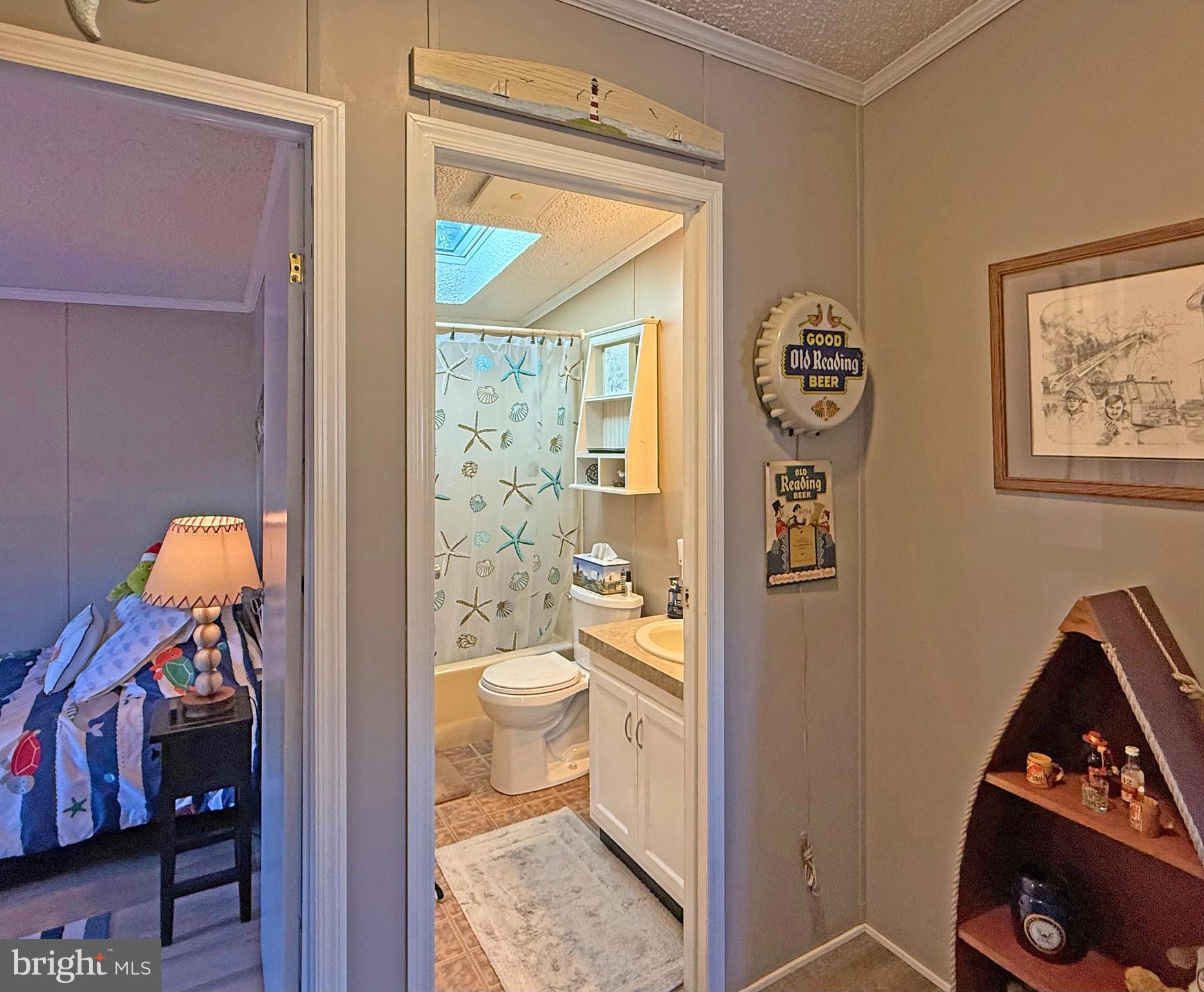 27137 Clipper Road, Unit M55 Millsboro, DE 19966 - Photo 35 of 48 a bathroom with a toilet and a shower curtain