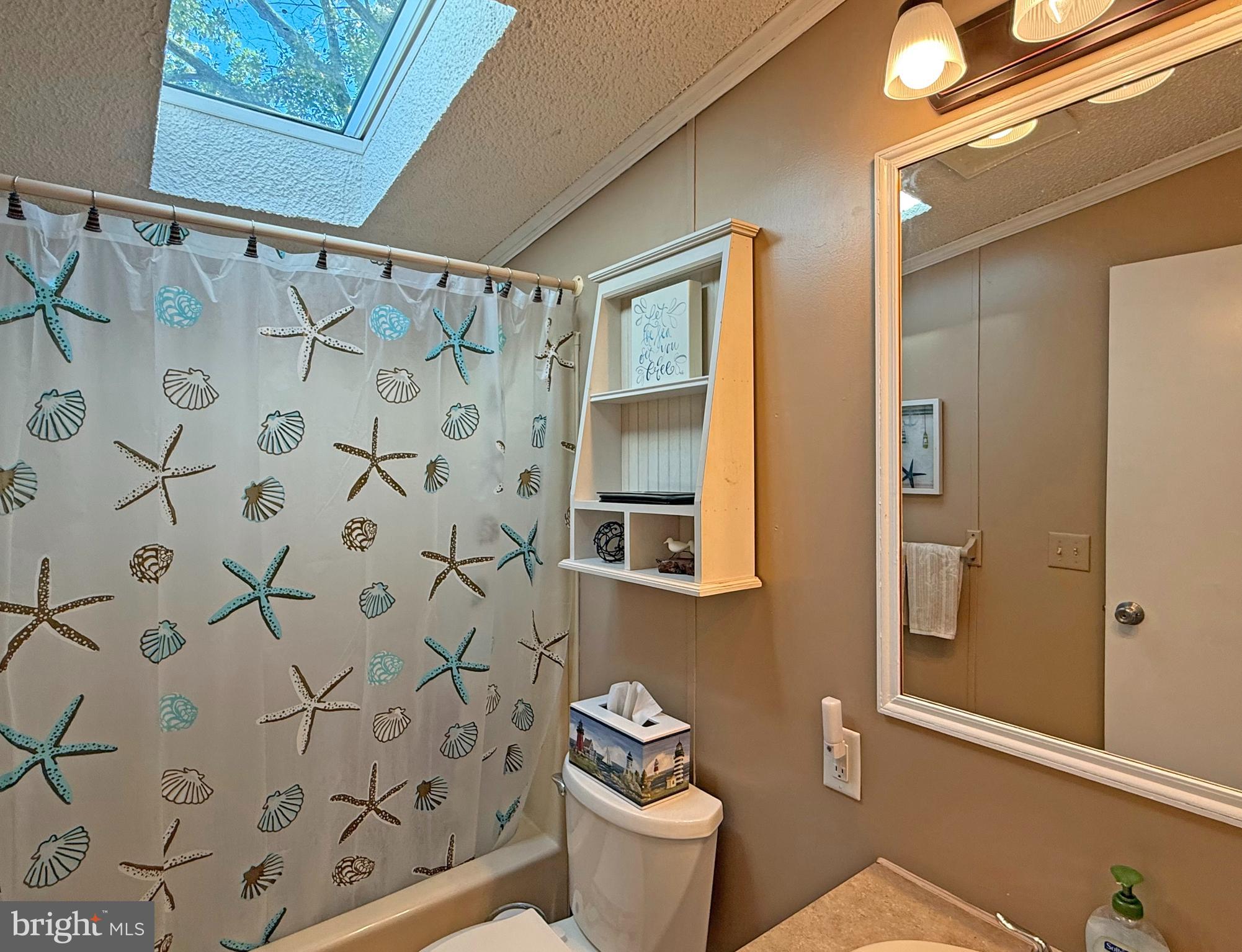 27137 Clipper Road, Unit M55 Millsboro, DE 19966 - Photo 36 of 48 a bathroom with a toilet and a shower curtain