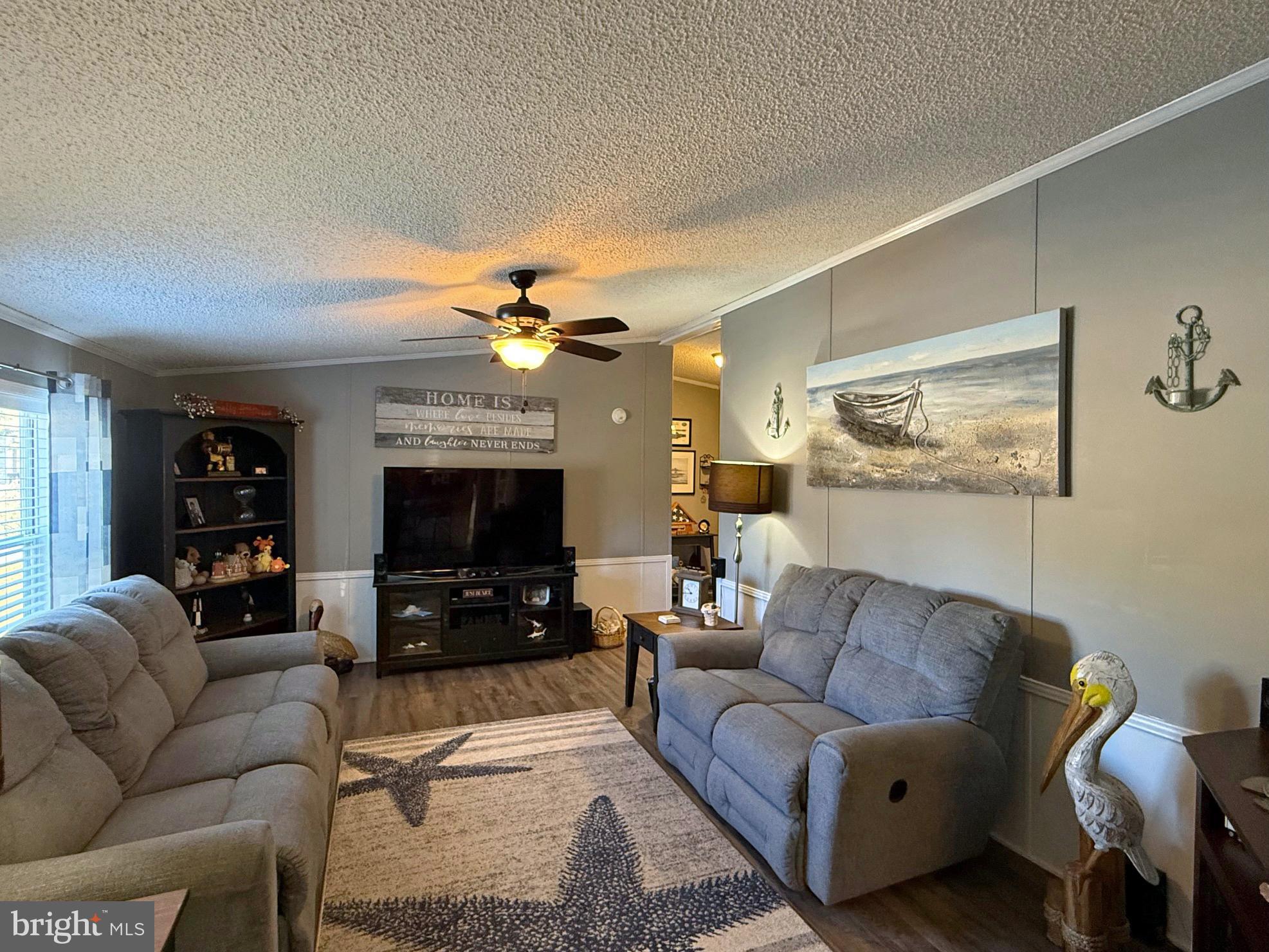 27137 Clipper Road, Unit M55 Millsboro, DE 19966 - Photo 4 of 48 a living room with furniture and a flat screen tv