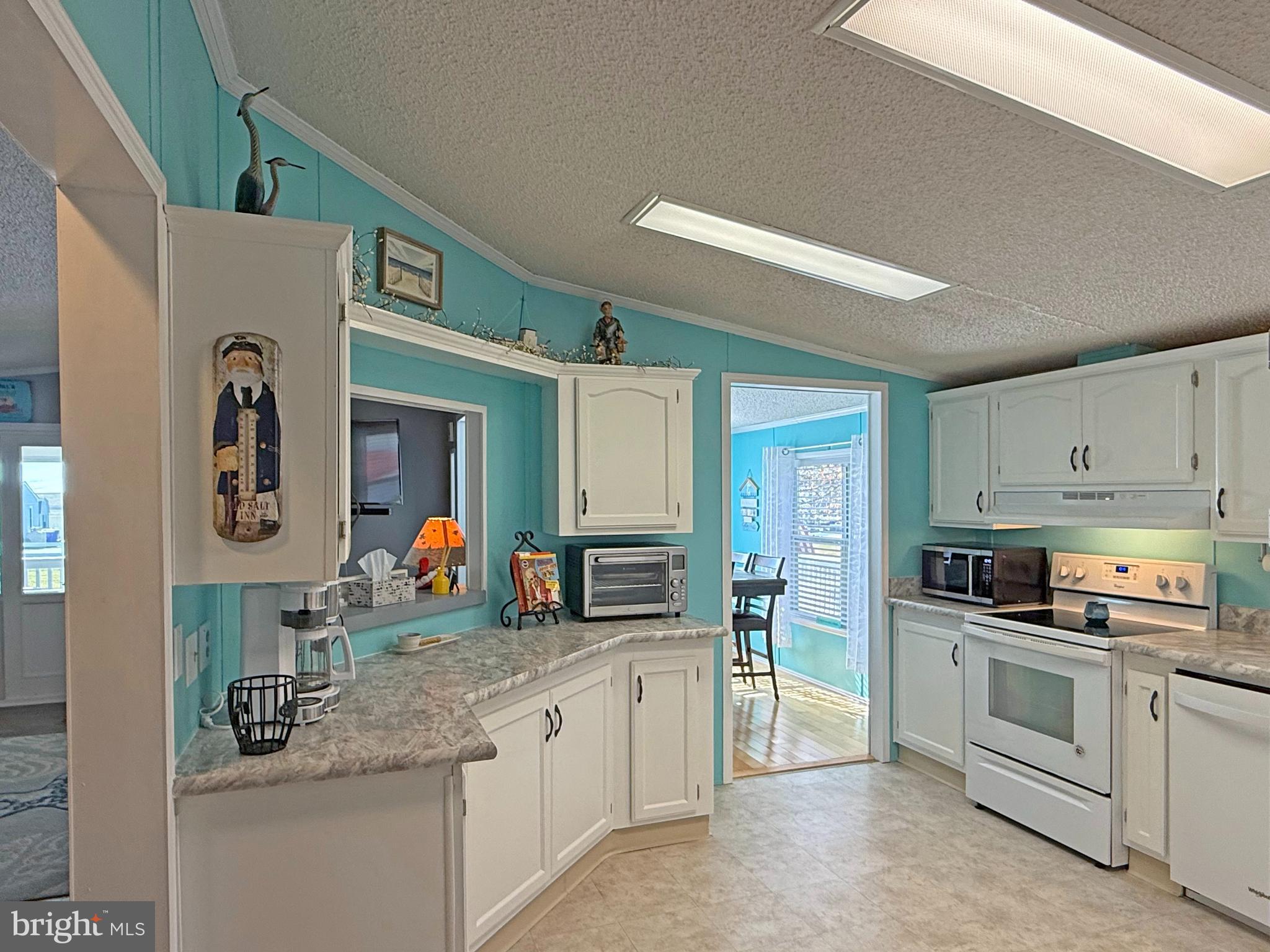 27137 Clipper Road, Unit M55 Millsboro, DE 19966 - Photo 8 of 48 a kitchen that has a lot of cabinets a sink and appliances