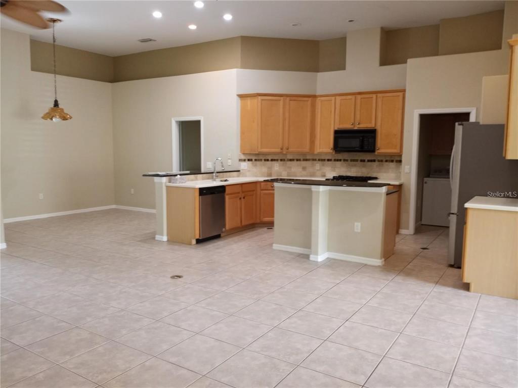 6506 Waters Edge Way Lakewood Ranch, FL 34202 - Photo 11 of 14 a kitchen with stainless steel appliances granite countertop a stove top oven a sink a counter top space and cabinets