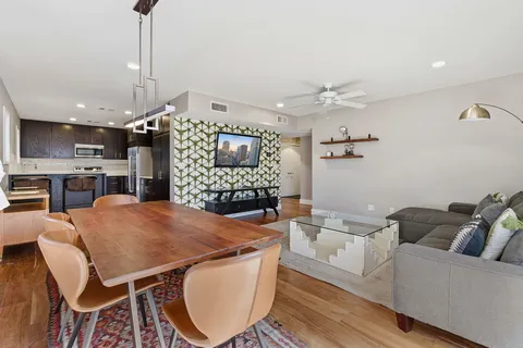 a living room with furniture a fireplace and a kitchen view