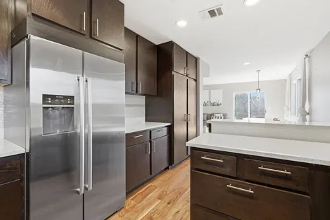 a kitchen with stainless steel appliances granite countertop a refrigerator and a sink