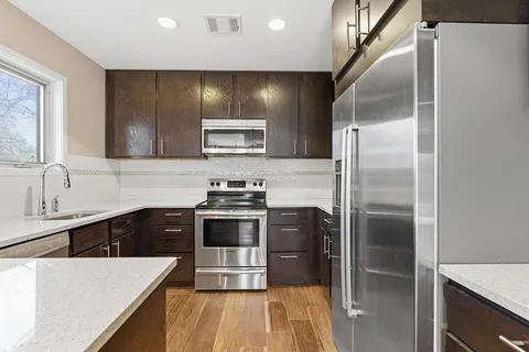 a kitchen with kitchen island a counter space a sink and stainless steel appliances