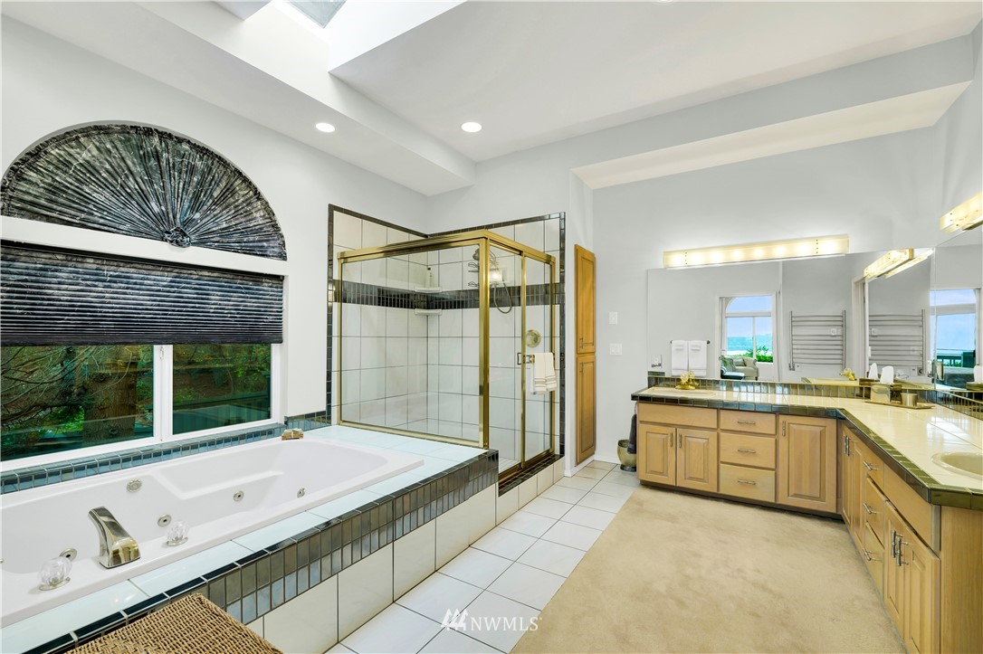 4191 Islander Way Anacortes, WA 98221 - Photo 21 of 40 a spacious bathroom with a granite countertop tub a mirror and shower