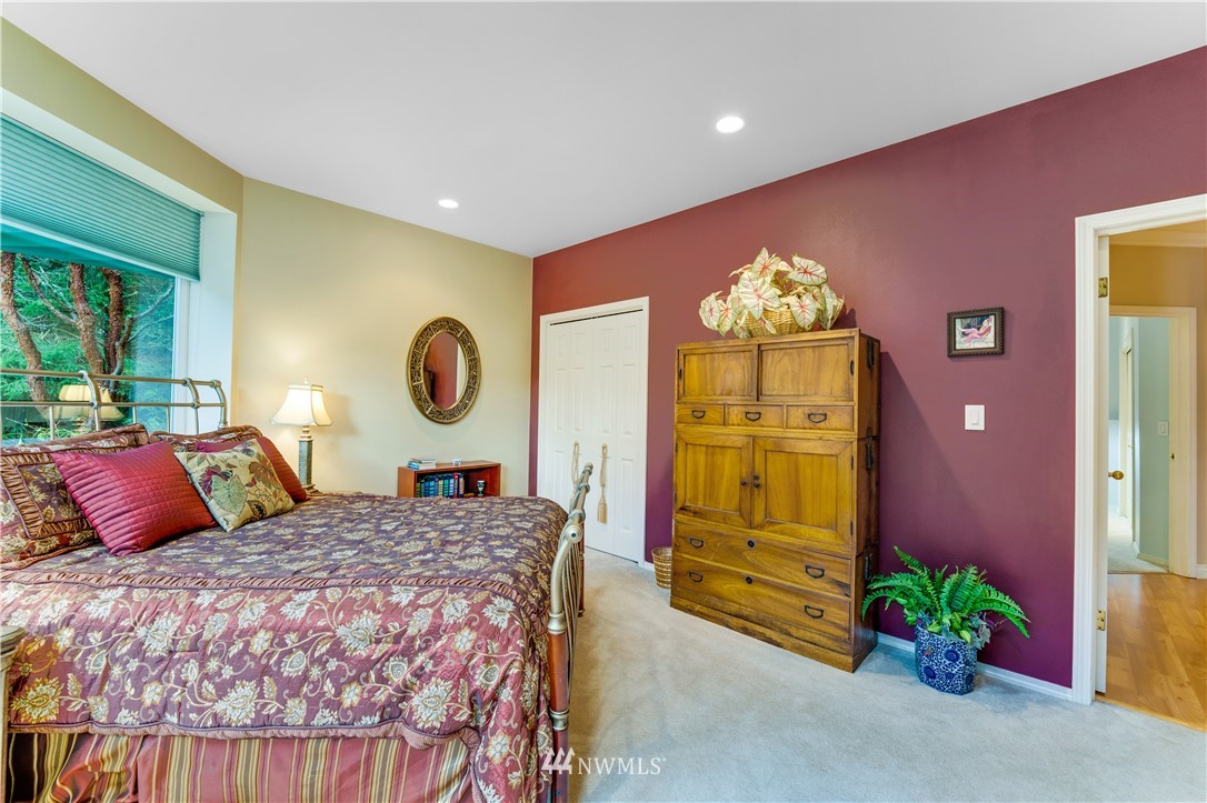 4191 Islander Way Anacortes, WA 98221 - Photo 24 of 40 a bedroom with a bed and dresser with mirror
