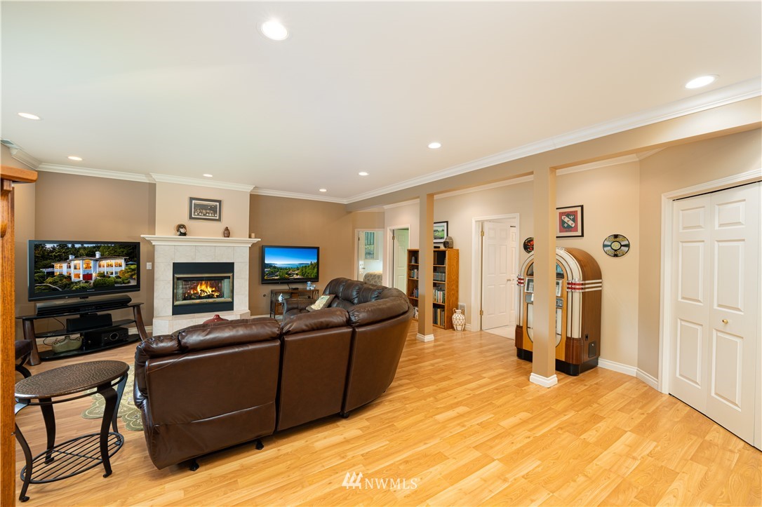4191 Islander Way Anacortes, WA 98221 - Photo 32 of 40 a living room with furniture a flat screen tv and a fireplace