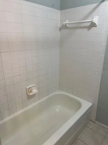 a bath tub sitting next to a white sink and vanity