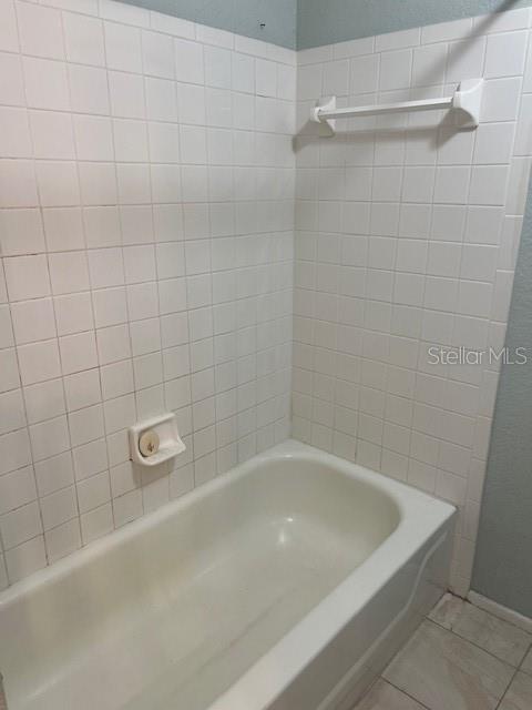 7757 Sugar Bend Drive, Unit 7757 Orlando, FL 32819 - Photo 17 of 30 a bath tub sitting next to a white sink and vanity