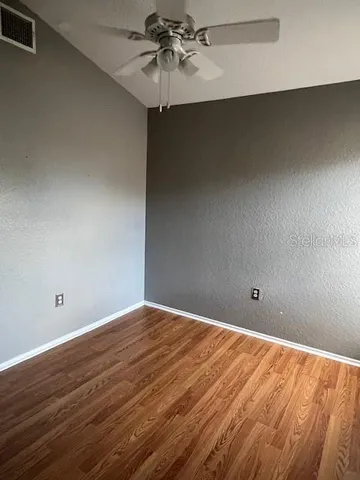 a view of an empty room with wooden floor
