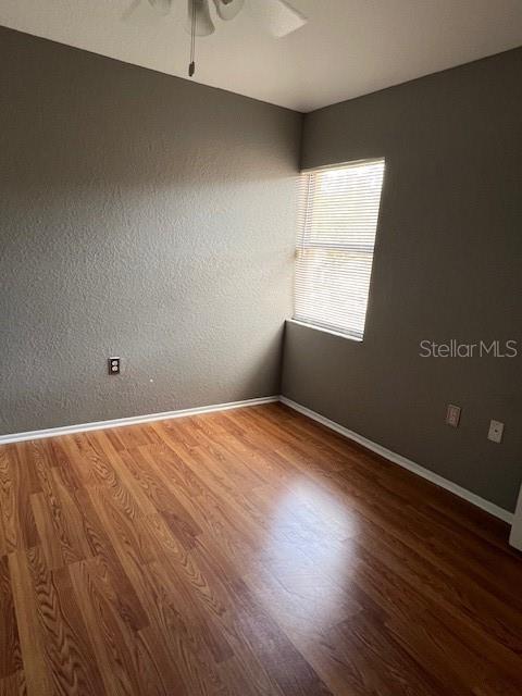 7757 Sugar Bend Drive, Unit 7757 Orlando, FL 32819 - Photo 19 of 30 an empty room with wooden floor and windows