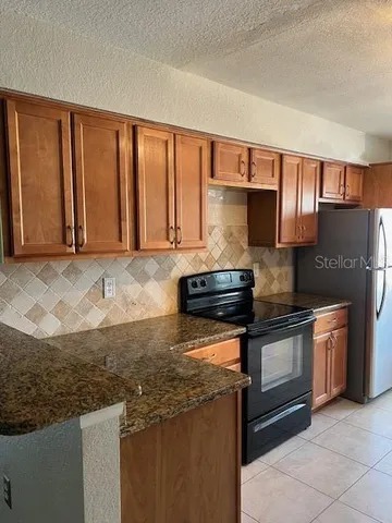 a kitchen with granite countertop a sink stove and cabinets