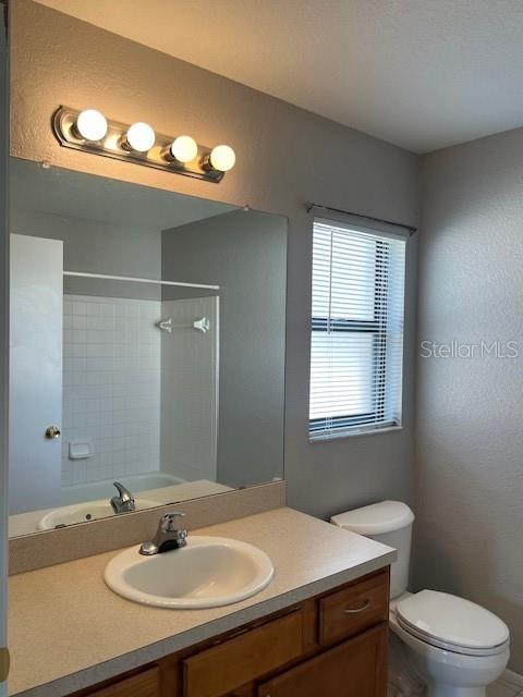 7757 Sugar Bend Drive, Unit 7757 Orlando, FL 32819 - Photo 8 of 30 a bathroom with a sink a toilet a mirror and a window