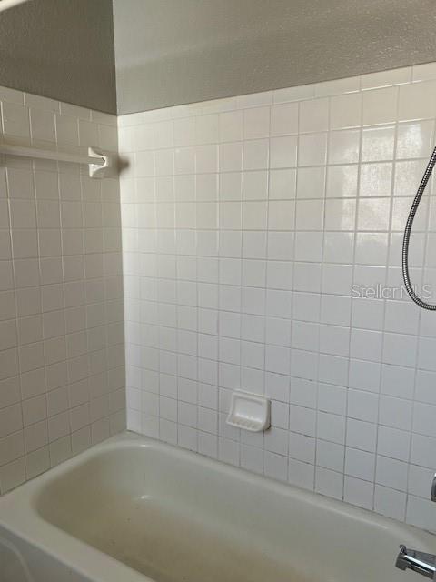 7757 Sugar Bend Drive, Unit 7757 Orlando, FL 32819 - Photo 9 of 30 a bathroom with a shower and a bathtub