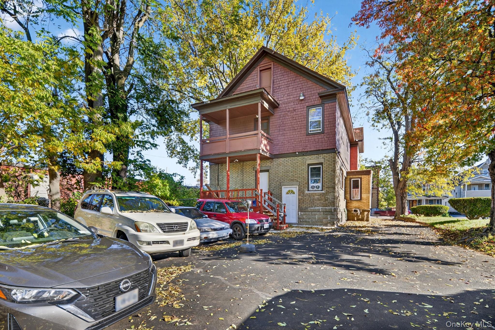 964 State Street Schenectady, NY 12307 - Photo 23 of 24 View of front of house featuring brick siding, a balcony, and uncovered parking
