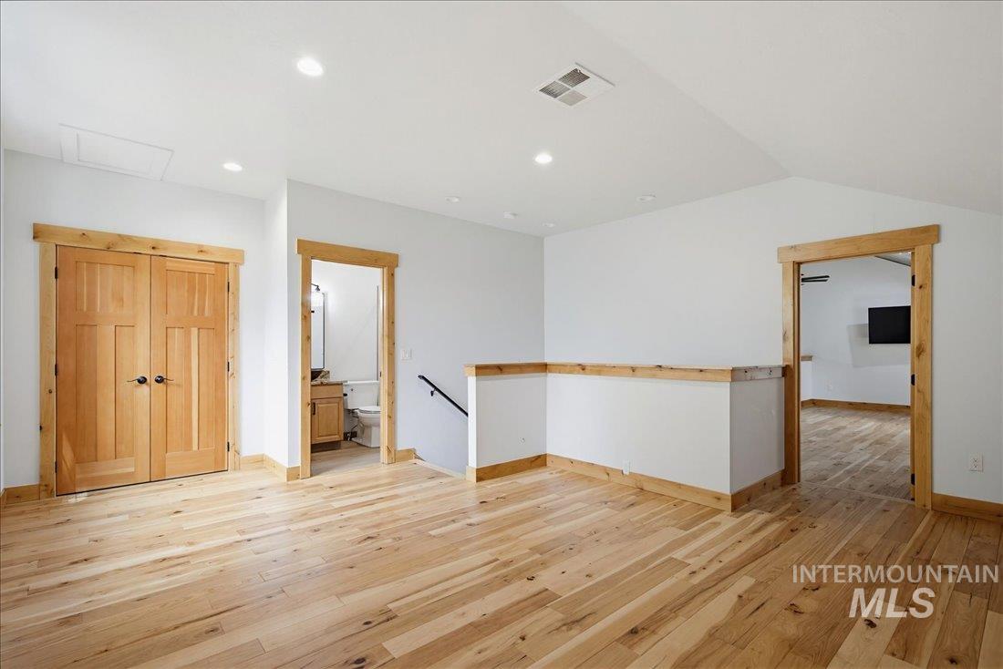 1051 Bitterroot Drive McCall, ID 83638 - Photo 17 of 26 Bright open-concept landing featuring light wood-finish flooring, recessed lighting, white walls, wood trim, and a wood half-wall with a black railing - Upstairs Romm - Considered 4th Bedroom