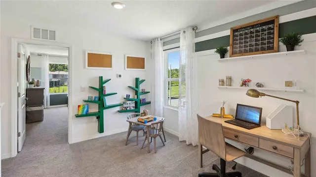 a view of a workspace with furniture and a window