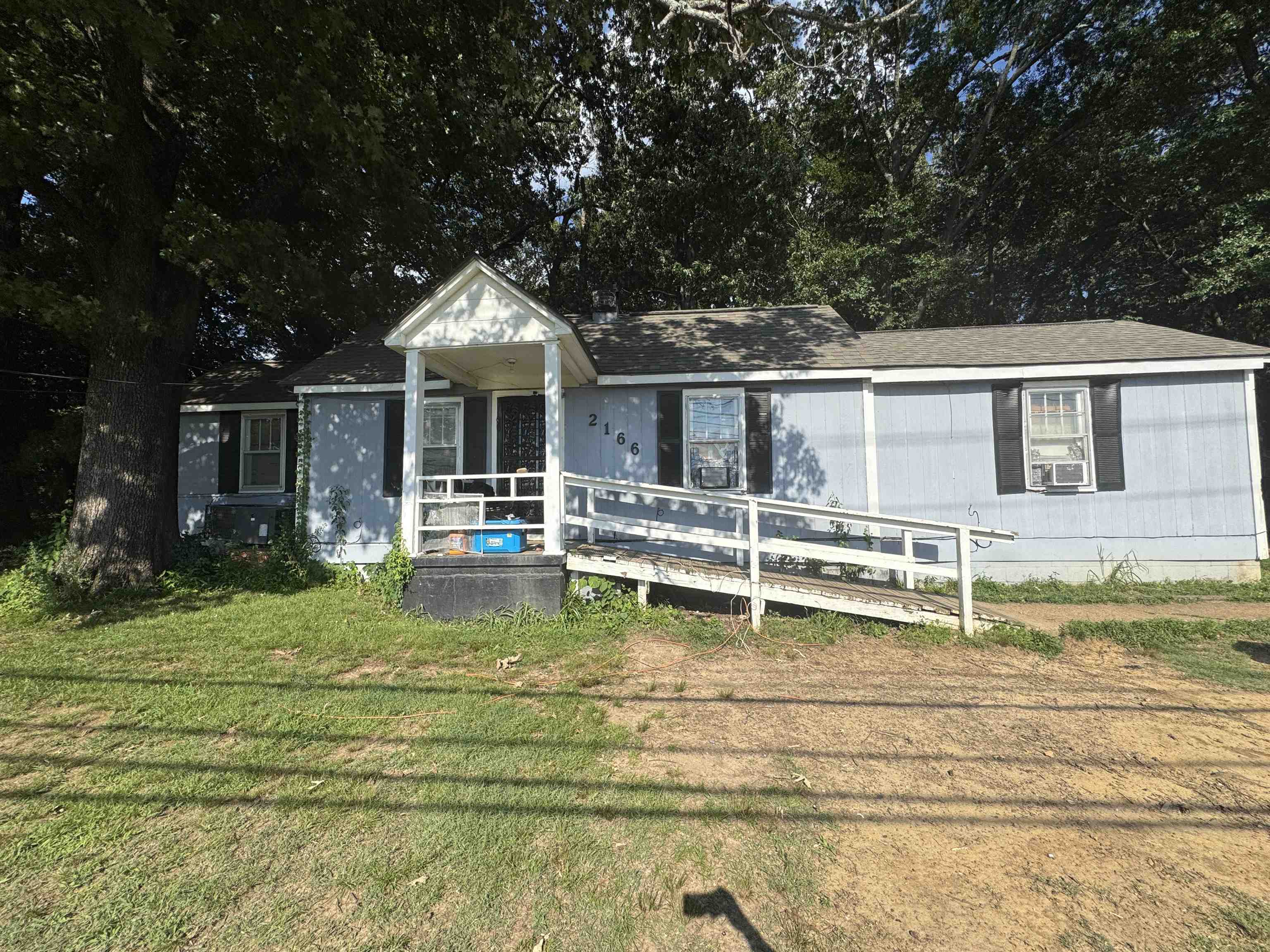 2166 Thomas Road Memphis, TN 38134 - Photo 1 of 10 Single-story residence featuring light blue siding, black window shutters, and a covered front porch with a white railing
