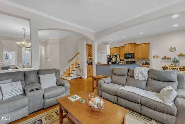 a living room with furniture kitchen view and a wooden floor